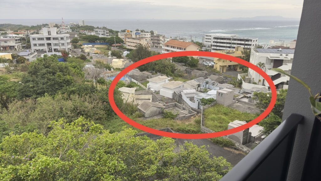 グランディスタイル沖縄読谷ホテル＆リゾートのデラックスセミスイートツインのバルコニーからお墓が見える